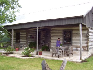 Thelma in front of Log Cabin